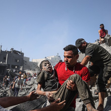KHAN YUNIS, GAZA - OCTOBER 26: A victim is being carried by the civilians after pulled from under the rubble in the city of Khan Yunis, Gaza where some buildings collapsed or heavily damaged in Israeli airstrikes on October 26, 2023. (Photo by Mustafa Hassona/Anadolu via Getty Images)