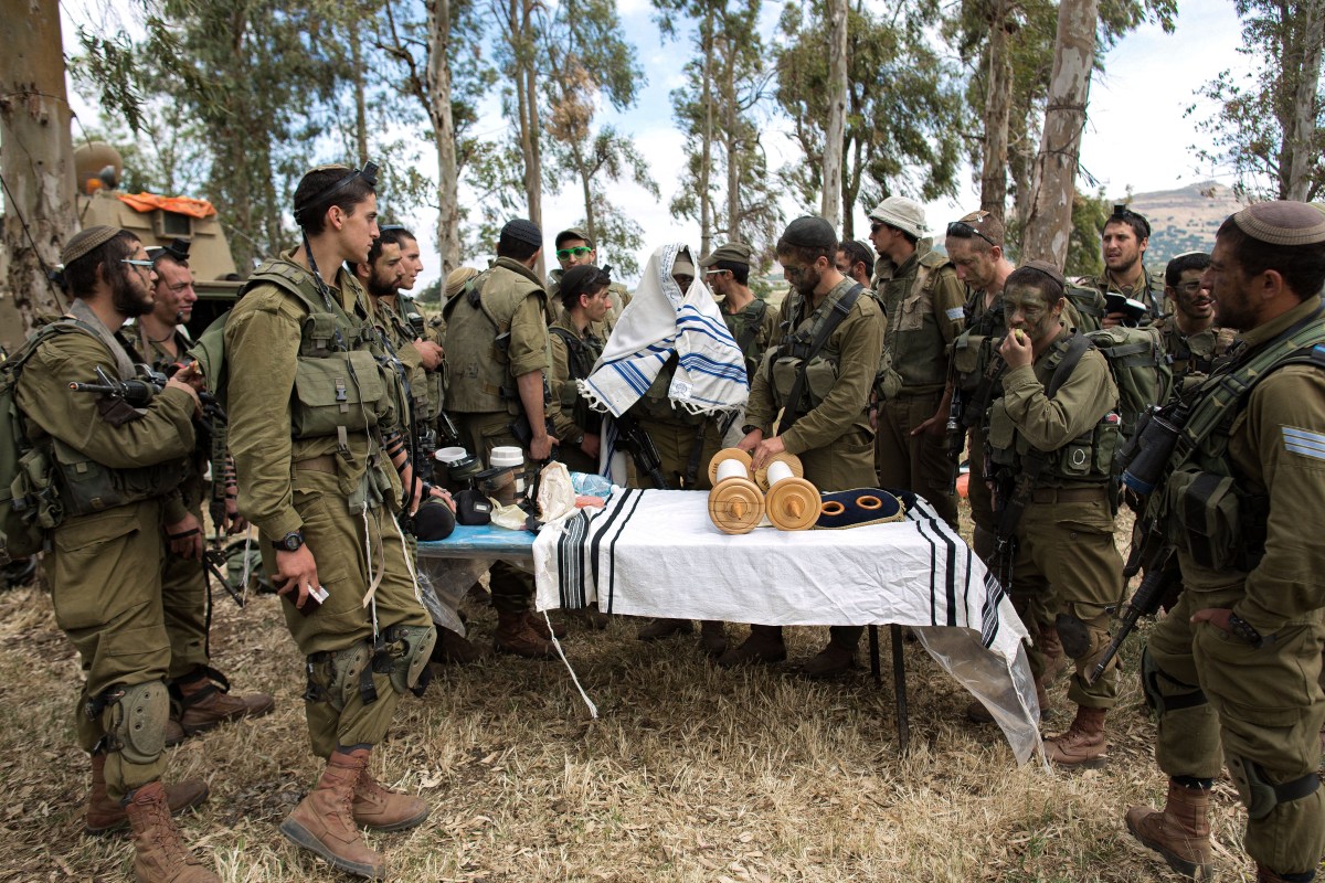 Israeli soldiers of the Jewish Ultra-Orthodox battalion "Netzah Yehuda" hold morning prayers as they take part in their annual unit training in the Israeli annexed Golan Heights, near the Syrian border on May 19, 2014. The Netzah Yehuda Battalion is a battalion in the Kfir Brigade of the Israel military which was created  to allow religious Israelis to serve in the army  in an atmosphere respecting their religious convictions. AFP PHOTO/MENAHEM KAHANA        (Photo credit should read MENAHEM KAHANA/AFP via Getty Images)