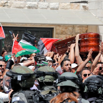 Violence erupts between Israeli security forces and Palestinian mourners carrying the casket of slain  Al-Jazeera journalist Shireen Abu Akleh out of a hospital, before being transported to a church and then her resting place, in Jerusalem, on May 13, 2022. - Abu Akleh, who was shot dead on May 11, 2022 while covering a raid in the Israeli-occupied West Bank, was among Arab media's most prominent figures and widely hailed for her bravery and professionalism. (Photo by Ahmad GHARABLI / AFP) (Photo by AHMAD GHARABLI/AFP via Getty Images)