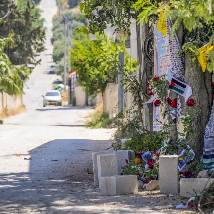 Flowers, flags and other memorabilia create a makeshift memorial at the site where  veteran Palestinian-American reporter Shireen Abu Akleh was shot and killed, in the West Bank city of Jenin, May 19, 2022. Almost two weeks after the death of Abu Akleh, a reconstruction by The Associated Press lends support to assertions from both Palestinian authorities and Abu Akleh's colleagues that the bullet that cut her down came from an Israeli gun. (AP Photo/Majdi Mohammed)