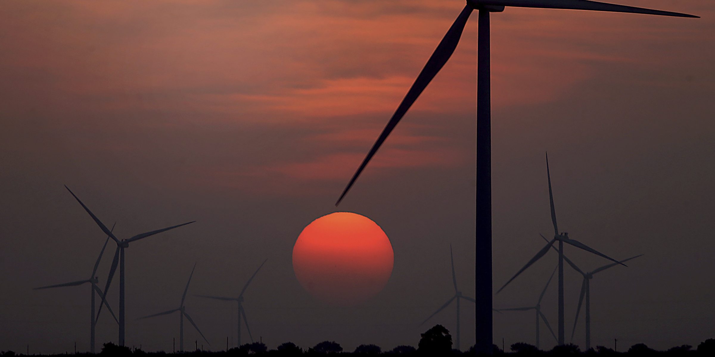 FILE - The sun sets at wind farm in McCook, Texas during a heat wave on July 20, 2022. Both sides of the political spectrum have their say about ESG: It’s either just a label that costs more, or it’s saving the world. Environmental, social and corporate governance criteria are factors for evaluating investments and companies, but have those criteria created any change? (Delcia Lopez/The Monitor via AP, File)