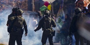 Police officers confront protesters in a gas cloud during a demonstration in opposition to a new police training center, Monday, Nov. 13, 2023, in Atlanta. (AP Photo/Mike Stewart)