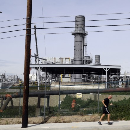 A jogger runs past the Scattergood power plant Tuesday, Feb. 12, 2019, in Los Angeles. Los Angeles will abandon a plan to spend billions of dollars rebuilding three natural gas power plants as the city moves toward renewable energy, Mayor Eric Garcetti said Monday. (AP Photo/Marcio Jose Sanchez)