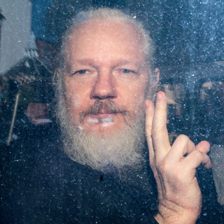 LONDON, ENGLAND - APRIL 11: Julian Assange gestures to the media from a police vehicle on his arrival at Westminster Magistrates court on April 11, 2019 in London, England.  After weeks of speculation Wikileaks founder Julian Assange was arrested by Scotland Yard Police Officers inside the Ecuadorian Embassy in Central London this morning. Ecuador's President, Lenin Moreno, withdrew Assange's Asylum after seven years citing repeated violations to international conventions. (Photo by Jack Taylor/Getty Images)