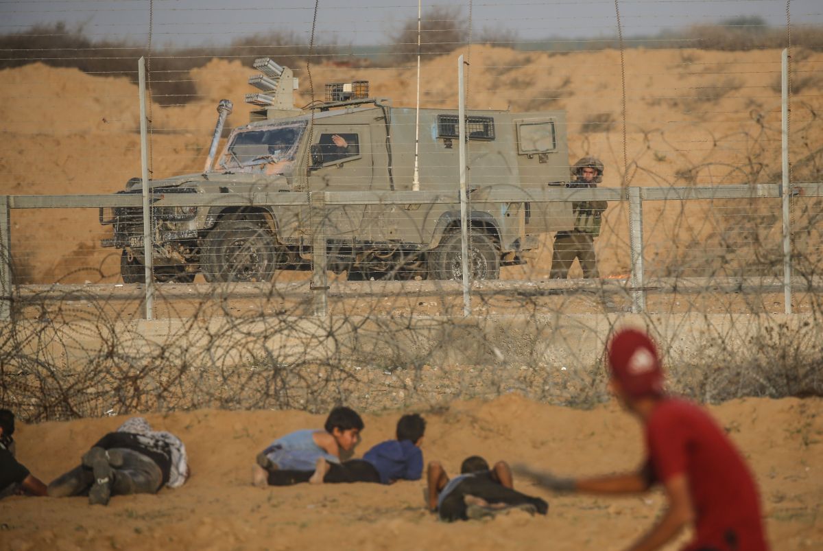 TOPSHOT - An Israeli soldier takes aim with a tear gas launcher at Palestinin protesters during clashes following a demonstration along the border fence east of Khan Yunis in the southern Gaza Strip on November 8, 2019. (Photo by SAID KHATIB / AFP) (Photo by SAID KHATIB/AFP via Getty Images)