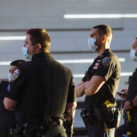 New York City Police Department (NYPD) officers wearing protective masks stand in Times Square in New York, U.S., on Tuesday, June 16, 2020. With two weeks to get City Council approval of a spending plan that plugs a $9 billion revenue gap in the next two years, Mayor Bill de Blasio faces renewed calls to slash more than $1 billion from the NYPD. Photographer: Angus Mordant/Bloomberg via Getty Images