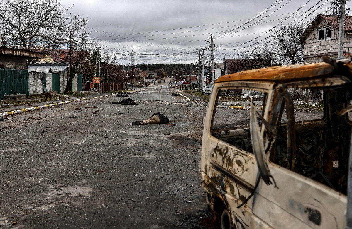 EDITORS NOTE: Graphic content / In this photo taken on April 02, 2022 bodies of civilian lie on Yablunska street in Bucha, northwest of Kyiv, after Russian army pull back from the city. The first body on the picture has been identified as Mykhailo Kovalenko and was shot dead by Russian soldiers according to relatives interviewed by AFP. When the 62-year-old arrived on Yablunska, he "got out of the vehicle with his hands up" to present himself to a checkpoint manned by Russian soldiers, said Artem, the boyfriend of Kovalenkos daughter. Still, the troops opened fire, said his daughter and his wife, who survived the attack by running away. - The bodies of at least 20 men in civilian clothes were found lying in a single street Saturday after Ukrainian forces retook the town of Bucha near Kyiv from Russian troops, AFP journalists said. Russian forces withdrew from several towns near Kyiv in recent days after Moscow's bid to encircle the capital failed, with Ukraine declaring that Bucha had been "liberated". (Photo by RONALDO SCHEMIDT / AFP) (Photo by RONALDO SCHEMIDT/AFP via Getty Images)