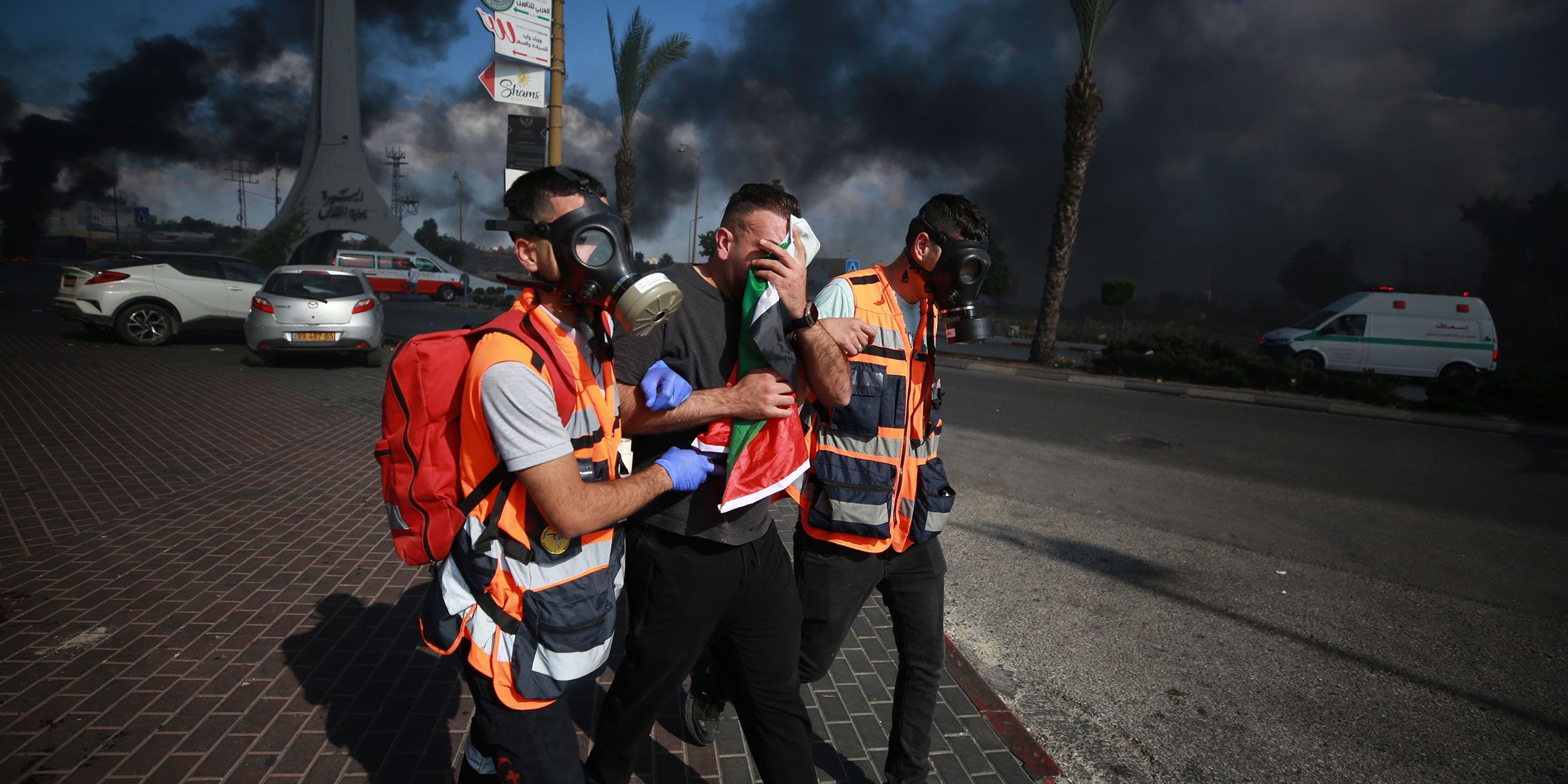 RAMALLAH, WEST BANK - OCTOBER 13: A Palestinian man receives medical assistance after he has been affected from the tear gas as Palestinians clash with Israeli forces in Beit El district of Ramallah, West Bank on October 13, 2023. (Photo by Issam Rimawi/Anadolu via Getty Images)