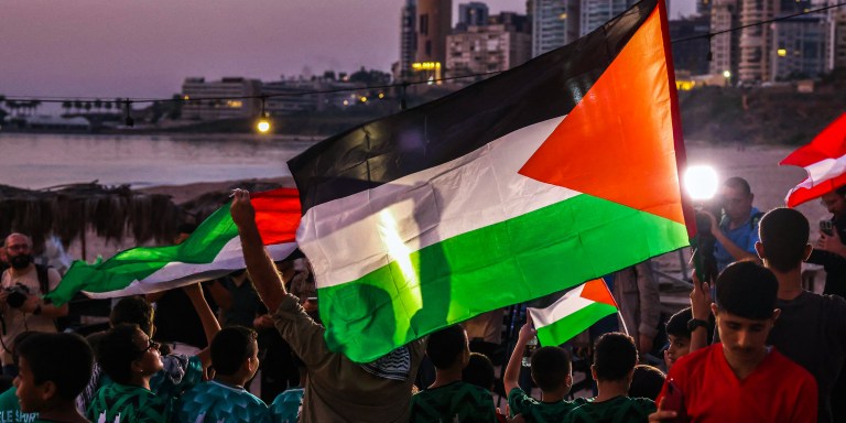 Children lift Palestinian flags during a solidarity vigil organized by Lebanon's Press Photographers Syndicate and the Ajial Social Communication Center, at the Ramlet al-Bayda beach in Beirut on October 22, 2023 in memory of killed Lebanese Journalist Issam Abdallah and in support of Palestinians amid the the ongoing battles between Israel and the Palestinian group Hamas in the Gaza Strip. (Photo by JOSEPH EID / AFP) (Photo by JOSEPH EID/AFP via Getty Images)