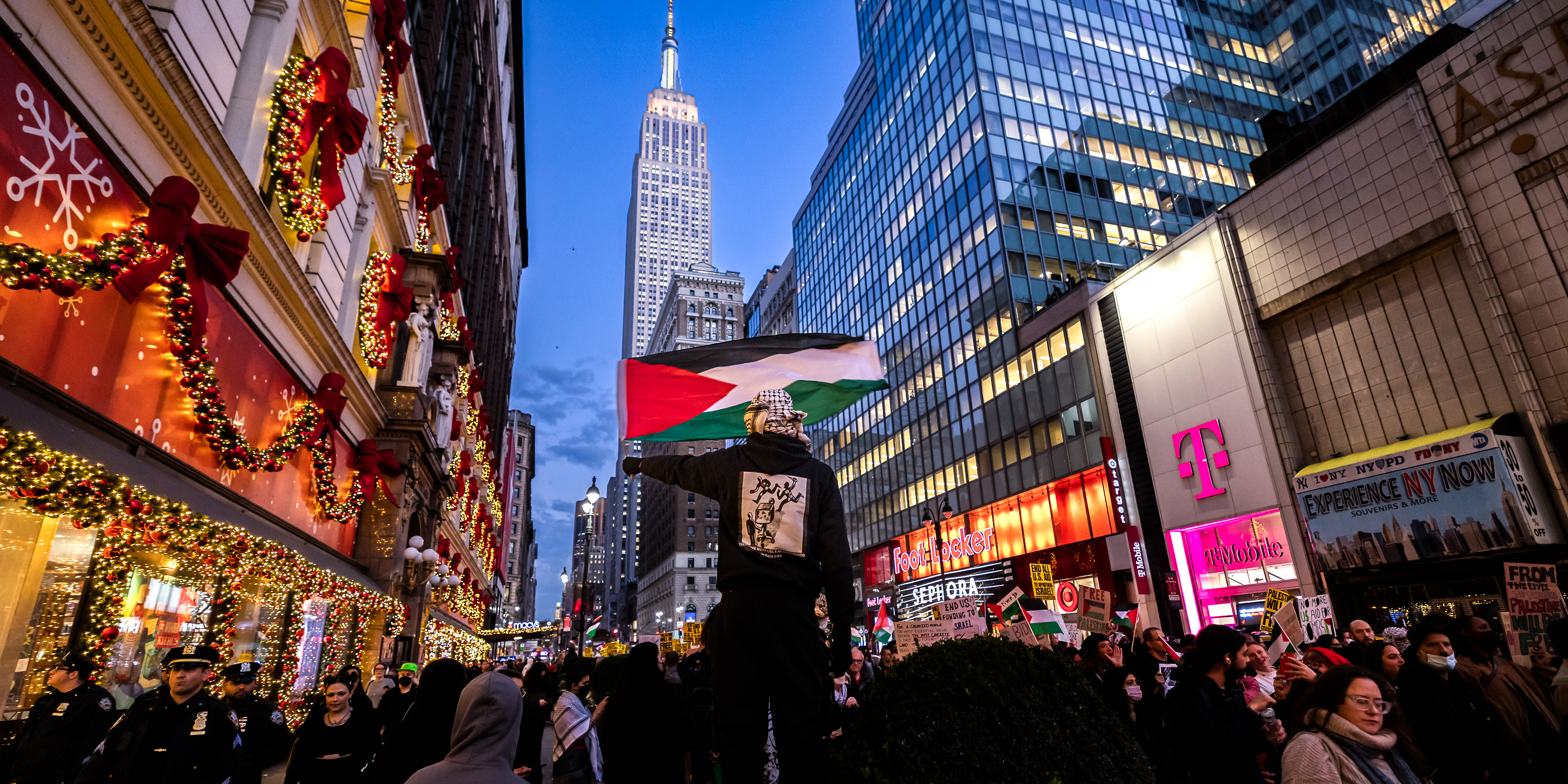 NEW YORK, UNITED STATES - 2023/11/09: A protester waves a Palestinian flag as others march past during a student walkout calling for a ceasefire between Israel and Hamas. Since October 7, the Israeli army's bombardment of the Palestinian enclave, in retaliation for the Hamas attack on Israel that killed over 1,400 people, has seen thousands of buildings razed to the ground, more than 10,000 people killed and 1.4 million displaced whilst Gaza remains besieged. (Photo by Michael Nigro/Pacific Press/LightRocket via Getty Images)