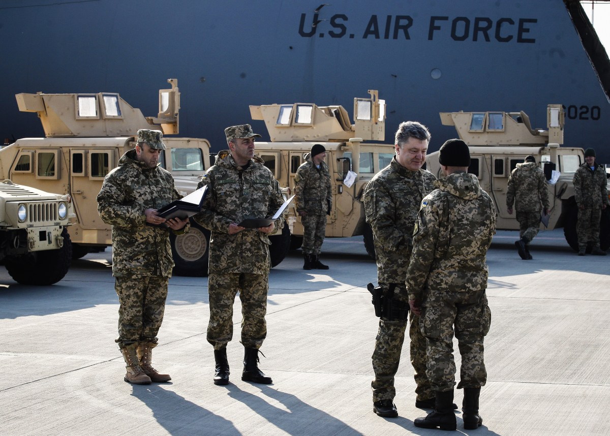 KIEV, UKRAINE - MARCH 25: Ukrainian President Petro Poroshenko (2nd R) gives certificates to Ukrainian servicemen, who will drive the newly delivered armored vehicles, at Boryspil airport on March 25, 2015 during a welcoming ceremony of the first US plane delivery of non-lethal aid, including 10 Humvee vehicles.Ukrainian President Petro Poroshenko took part in the ceremony of meeting the US Air Force plane with the first part of American military vehicles Humvees, which were supplied according to US decision to help Ukraine with defense aid. Ukraine plan to receive a total of 230 Humvee military vehicles during the next 45 days, according to Ukrainian officials. (Photo by Vladimir Shtanko/Anadolu Agency/Getty Images)