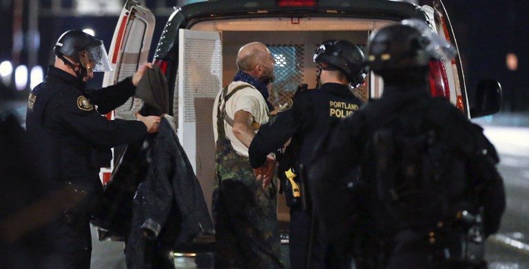 A protester is arrested as a crowd marches in protest through the streets of Portland, Ore., following Donald Trump's presidential inauguration, Friday, Jan. 20, 2017. Police in Portland used incendiary devices and tear gas to disperse a crowd of people protesting President Trump. (Dave Killen/The Oregonian via AP)