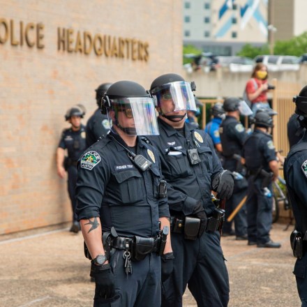 Police officers watch protesters demonstrating against police brutality outside of City of Austin Police Department headquarters in downtown in Austin, Texas on May 30, 2020.